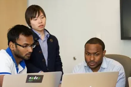 The UBound team huddled around computers, working together.